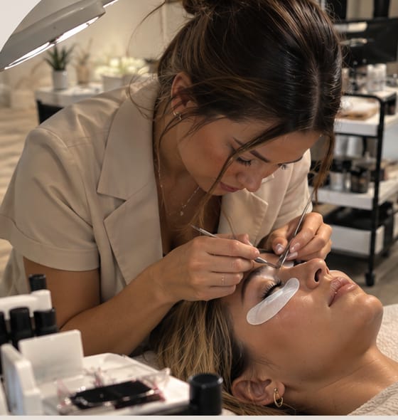 Kosmetikerin bei einer Wimpernbehandlung im Studio